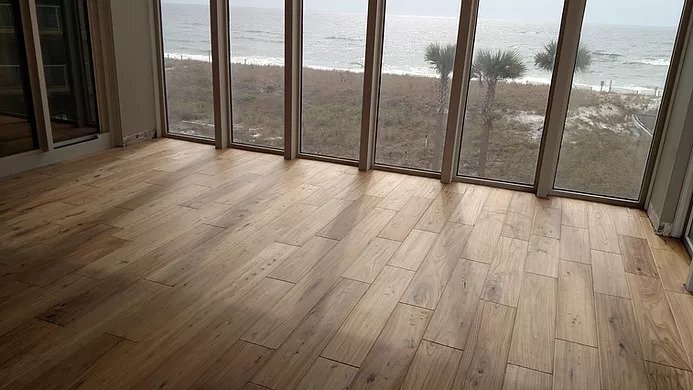 Glue-down hardwood flooring installation in Gulf Breeze with ocean view windows